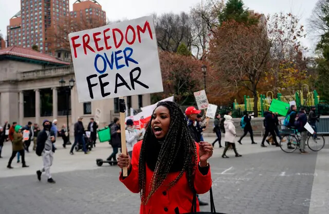 Um manifestante segura uma placa durante um protesto anti-lockdown na cidade de Nova York, em 22 de novembro de 2020. (Timothy A. Clary/AFP/Getty Images)
