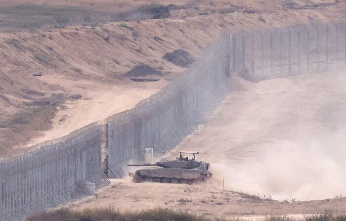 Um tanque israelense atravessa a cerca de segurança entre Israel e Gaza, na parte norte da Faixa de Gaza, visto de Sderot, Israel, em 12 de novembro de 2023 (EFE/EPA/NEIL HALL)