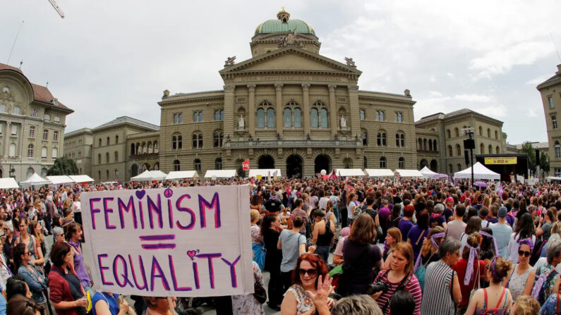 Uma mulher segura uma placa que diz “Feminismo = Igualdade” enquanto participa de uma greve nacional de mulheres pela igualdade salarial fora do palácio federal na capital suíça, Berna, em 14 de junho de 2019  (Stefan Wermuth/AFP/Getty Images)
