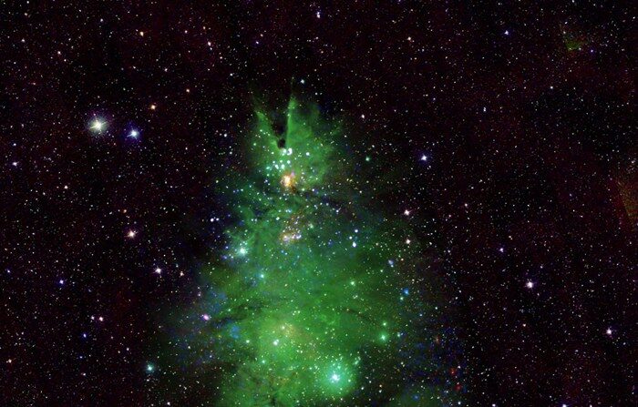 Os observatórios astronômicos da NASA capturaram um aglomerado de estrelas jovens, localizado a cerca de 2.500 anos-luz da Terra, e aprimoraram as cores e formas que compõem esse conjunto de luzes para compará-lo a uma árvore de Natal (Imagem: NASA)