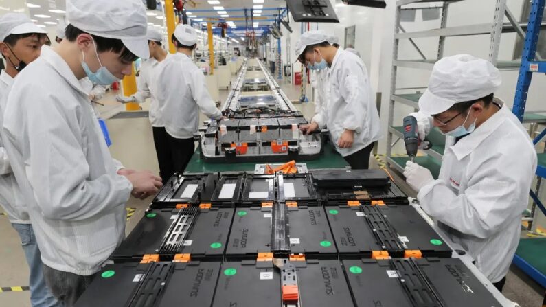 Trabalhadores em uma fábrica da Xinwangda Electric Vehicle Battery Co., que fabrica baterias de lítio para carros elétricos e outros usos, em Nanjing, na província de Jiangsu, no leste da China, em 12 de março de 2021. (STR/AFP via Getty Images)
