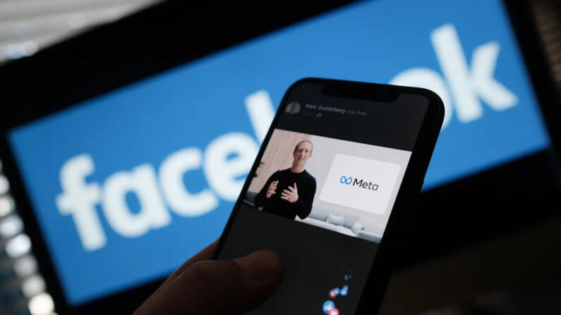 Uma pessoa usa um smartphone para assistir o CEO do Facebook, Mark Zuckerberg, revelar o logotipo META em Los Angeles em 28 de outubro de 2021 (Chris Delmas/AFP via Getty Images)
