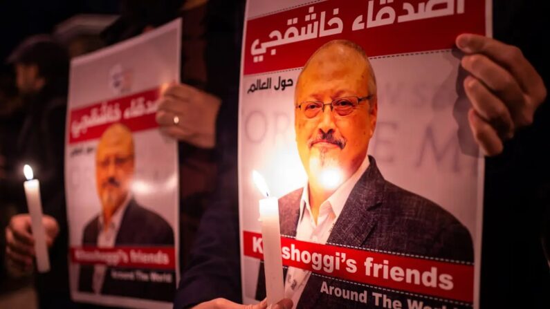 Pessoas seguram cartazes retratando o jornalista saudita Jamal Khashoggi assassinado durante uma reunião em frente ao Consulado da Arábia Saudita em Istambul, em 25 de outubro de 2018. (Yasin Akgul/AFP via Getty Images)