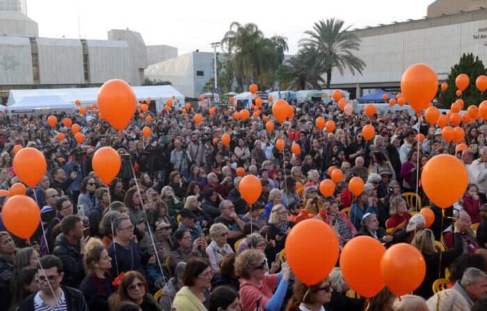 Pessoas seguram balões laranja enquanto participam de uma cerimônia para marcar o primeiro aniversário da criança israelense Kfir Bibas, que é mantida refém pelo Hamas em Gaza, do lado de fora da base militar de Kirya, em Tel Aviv, Israel, em 18 de janeiro de 2024 (EFE/EPA/ABIR SULTAN)