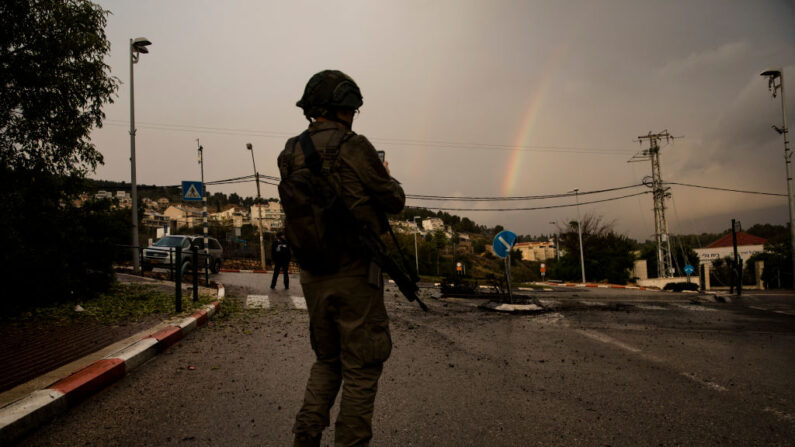 Trabalhadores de emergência israelenses inspecionam uma estrada danificada, depois de ter sido atingida por um foguete disparado do Líbano, em 11 de janeiro de 2024, em Kiryat Shemona, Israel (Foto: Amir Levy/Getty Images)