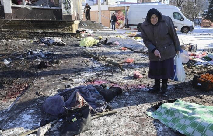 Uma mulher caminha entre os corpos das vítimas do bombardeio de 21 de janeiro em um mercado em Donetsk, na Ucrânia (EFE/EPA/ALESSANDRO GUERRA).