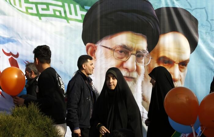 Iranianos caminham ao lado de fotos do falecido líder supremo iraniano, aiatolá Ruhollah Khomeini (dir.), e do líder supremo iraniano, aiatolá Ali Khamenei, enquanto comemoram o 45º aniversário da Revolução Islâmica em Teerã, Irã, em 11 de fevereiro de 2024 (EFE/EPA/ABEDIN TAHERKENAREH)