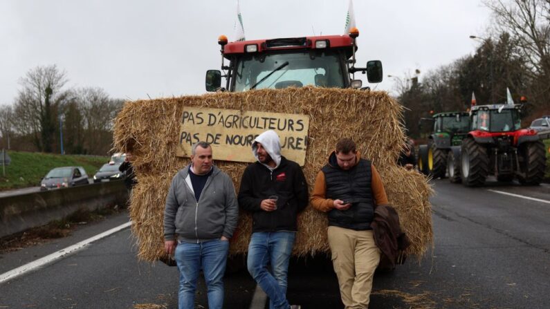 Manifestantes em pé no bloqueio de seus tratores na rodovia A6, perto de Chilly-Mazarin, ao sul de Paris, em 1º de fevereiro de 2024, enquanto os agricultores franceses mantêm bloqueios nas principais rodovias que levam a Paris pelo quarto dia, como parte dos protestos nacionais convocados por vários sindicatos de agricultores sobre salários, impostos e regulamentações (Foto: EMMANUEL DUNAND/AFP via Getty Images)