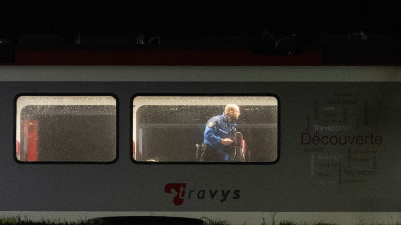 Um policial da Gendarme suíça inspeciona o interior de um trem, onde os passageiros que viajavam de Yverdon para Sainte-Croix foram mantidos como reféns, em Essert-Sous-Champvent, oeste da Suíça, em 8 de fevereiro de 2024. De acordo com a polícia e o jornal on-line 24 Heures, os passageiros do trem foram feitos reféns por um homem armado com um machado e libertados sem ferimentos (Foto: FABRICE COFFRINI/AFP via Getty Images)