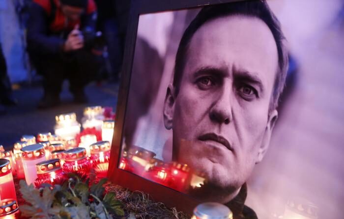 Velas e flores ao lado da foto do falecido líder da oposição russa Alexey Navalny durante uma vigília após sua morte, do lado de fora da Embaixada da Rússia em Riga, Letônia, em 16 de fevereiro de 2024 (EFE/EPA/TOMS KALNINS)