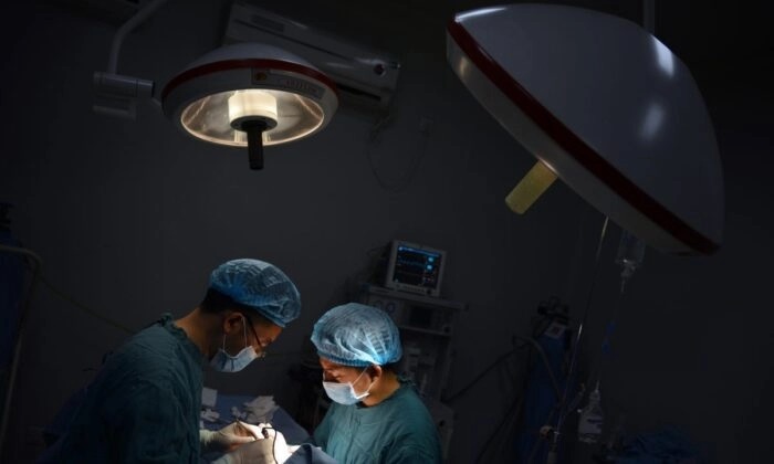 Dois médicos realizam cirurgia em Chongqing, China, em 9 de agosto de 2013. (Peter Parks/AFP/Getty Images)
