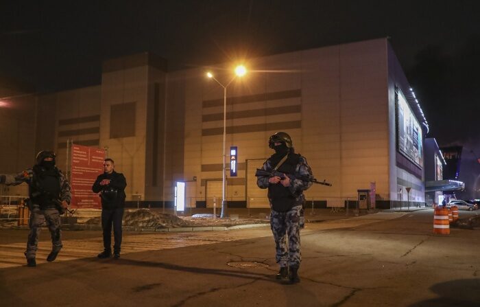  Policiais russos montam guarda perto da casa de shows Crocus City Hall em chamas após um tiroteio em Krasnogorsk, nos arredores de Moscou, Rússia, 22 de março de 2024 ( EFE/EPA/MAXIM SHIPENKOV)