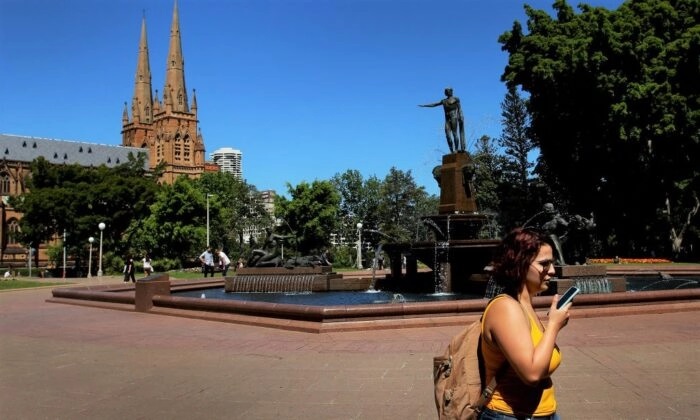 Uma mulher fala ao telefone enquanto caminha pelo Hyde Park em Sydney, Austrália, em 22 de outubro de 2019. (Lisa Maree Williams/Getty Images)
