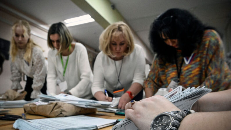 Membros de uma comissão eleitoral local contam cédulas em uma seção eleitoral após o último dia da eleição presidencial russa de três dias em Moscou, em 17 de março de 2024 (Foto de ALEXANDER NEMENOV/AFP via Getty Images)