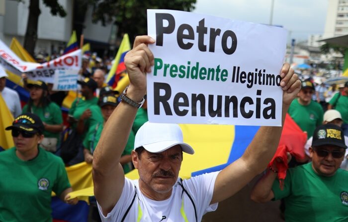 Um homem segura um cartaz protestando contra o presidente colombiano Gustavo Petro durante uma passeata contra o governo em Cali na quarta-feira (EFE/Ernesto Guzmán)