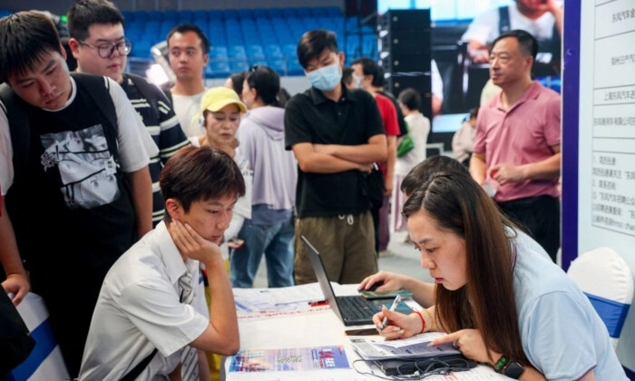 Licenciados universitários assistem a uma feira de emprego em Wuhan, na província central chinesa de Hubei, a 10 de agosto de 2023 (TR/AFP via Getty Images)
