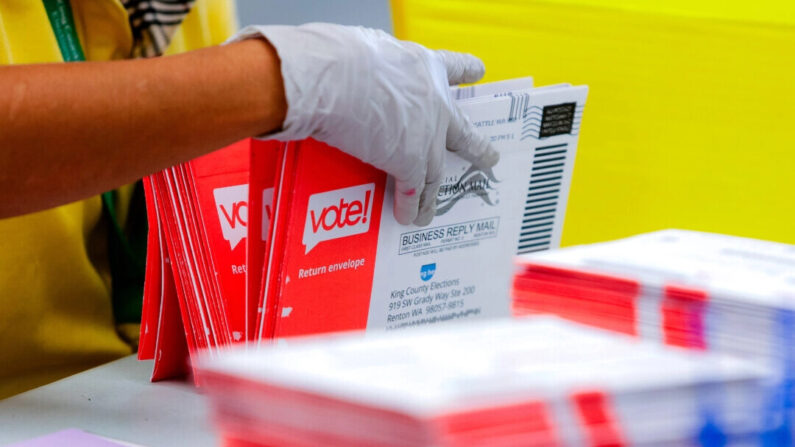 Um funcionário eleitoral abre envelopes contendo cédulas de voto por correio em uma foto de arquivo (Jason Redmond/AFP via Getty Images)
