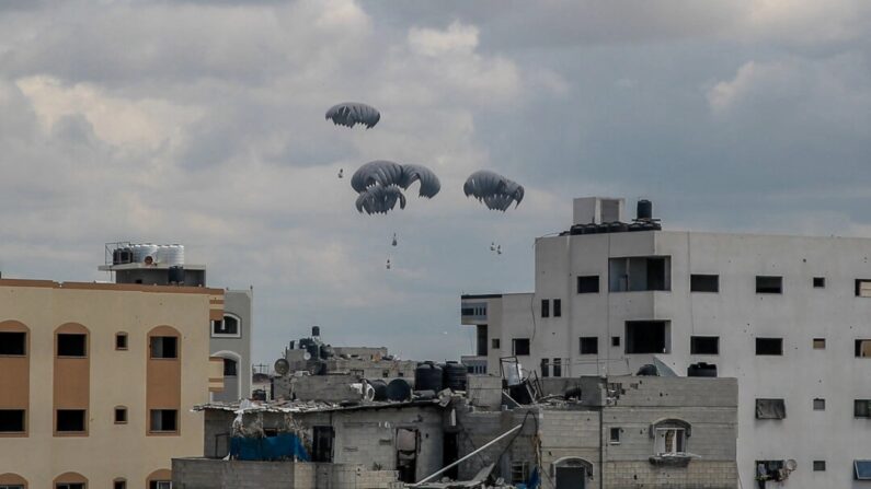 Pacotes de ajuda humanitária presos a paraquedas são lançados de uma aeronave militar sobre a Faixa de Gaza em 25 de março de 2024. (-/AFP via Getty Images)
