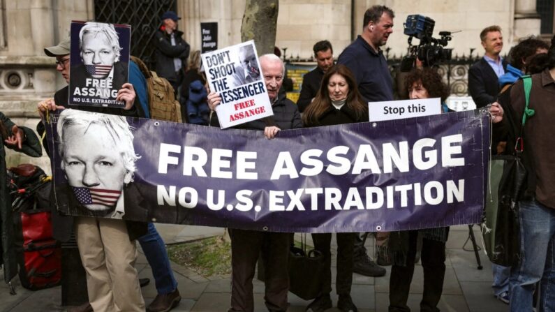 Apoiadores do fundador do WikiLeaks, Julian Assange, seguram uma faixa e cartazes em frente ao Royal Courts of Justice, o Supremo Tribunal da Grã-Bretanha, no centro de Londres, em 26 de março de 2024. (Daniel Leal/AFP via Getty Images)
