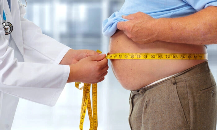 Médico medindo a gordura corporal da cintura do homem obeso (Shutterstock)
