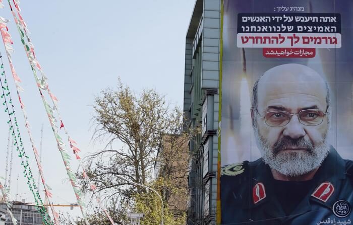 Um cartaz em grande escala exibindo uma foto do general de brigada iraniano Mohammad Reza Zahedi, comandante da Força Quds da Guarda Revolucionária Islâmica (IRGC), e a frase "Você (Israel) será punido" está pendurado na fachada de um prédio em Teerã, Irã, em 3 de abril de 2024 (EFE/EPA/ABEDIN TAHERKENAREH)