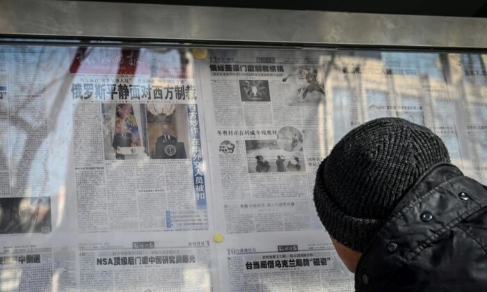 Um homem lê o jornal estatal chinês com cobertura do conflito entre Rússia e Ucrânia, em uma rua de Pequim, em 24 de fevereiro de 2022. (Jade Gao/AFP via Getty Images)

