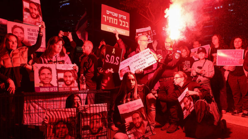 Parentes e simpatizantes de reféns israelenses mantidos em Gaza desde os ataques de 7 de outubro por militantes do Hamas seguram cartazes durante uma manifestação em Tel Aviv, em 26 de março de 2024, em meio ao conflito em curso na Faixa de Gaza entre Israel e o movimento militante palestino Hamas (Foto de JACK GUEZ/AFP via Getty Images)