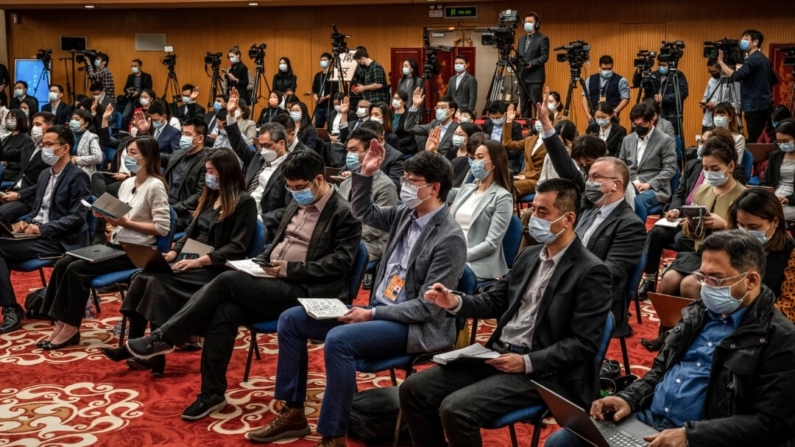 Jornalistas levantam as mãos para fazer perguntas em uma coletiva de imprensa em Pequim, em 7 de março de 2022. (Andrea Verdelli/Getty Images)
