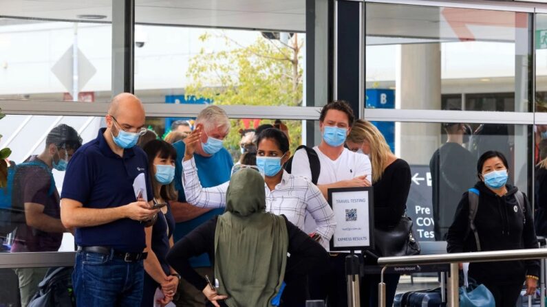 Pessoas fazem fila na clínica de testes de COVID da Histopath antes de embarcar no Aeroporto Internacional de Sydney em 23 de dezembro de 2021 em Sydney, Austrália. A demanda nos centros de testes de COVID-19 em Sydney aumentou antes do Natal, à medida que o número de casos de coronavírus em NSW aumentava. As pessoas que viajavam para Queensland, Tasmânia e Sul da Austrália foram obrigadas a apresentar um teste PCR negativo para entrar nesses estados, enquanto as fronteiras da Austrália Ocidental estão fechadas para viajantes de NSW. (Foto de Jenny Evans/Getty Images)
