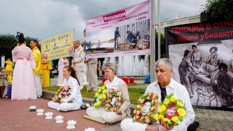 Praticantes do Falun Gong se reúnem na praça em frente à Estação Finlyandsky em São Petersburgo, Rússia, em 20 de julho de 2013, para comemorar os praticantes que foram perseguidos até a morte na China. (Irina Oshirova/Epoch Times)