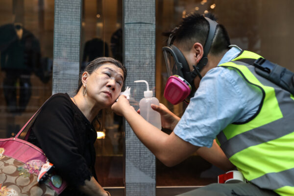 Uma mulher é tratada depois que a polícia disparou gás lacrimogêneo para dispersar manifestantes no distrito central de Hong Kong em 12 de novembro de 2019 (Dale De La Rey / AFP via Getty Images)