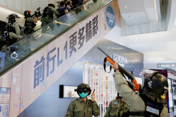 A polícia de choque levanta seu projétil de spray de pimenta dentro de um shopping center enquanto dispersa manifestantes antigovernamentais durante um comício, em Hong Kong, China, em 10 de maio de 2020 (Tyrone Siu / Reuters)