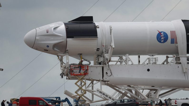 Os trabalhadores preparam o foguete SpaceX Falcon 9 com a sonda Crew Dragon anexada para a decolagem na Plataforma de Lançamento 39A no Centro Espacial Kennedy em Cape Canaveral, Flórida, em 26 de maio de 2020 (Joe Raedle / Getty Images)