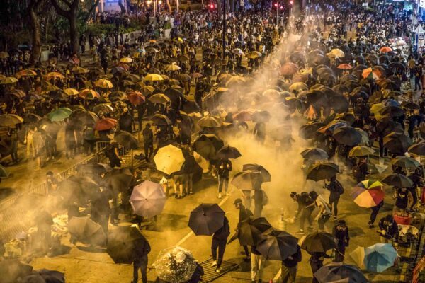 Manifestantes reagem quando a polícia dispara gás lacrimogêneo enquanto tentam marchar em direção à Universidade Politécnica de Hong Kong em 18 de novembro de 2019 (Dale de la Rey / AFP via Getty Images)