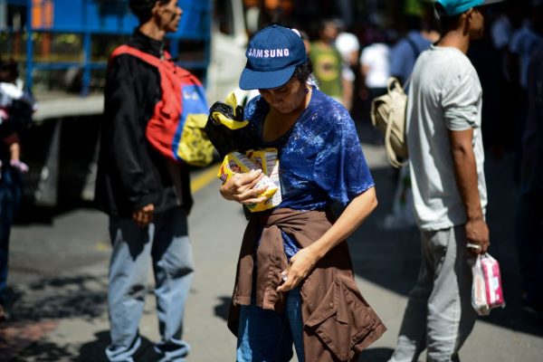 Mulher segura dois sacos de farinha após fazer fila em frente a um supermercado em Caracas (Venezuela) para comprar alimentos básicos e produtos domésticos em 10 de novembro de 2017 (FEDERICO PARRA / AFP via Getty Images)