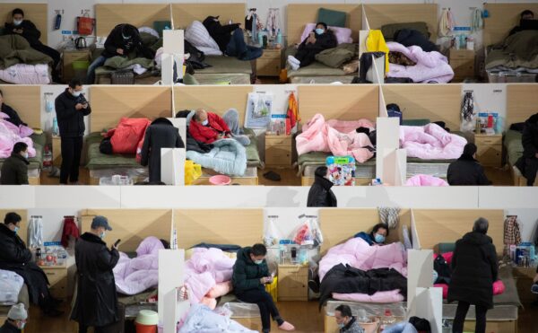 Pacientes com sintomas leves do coronavírus COVID-19 estão descansando à noite no hospital improvisado instalado em um estádio esportivo em Wuhan, China, em 18 de fevereiro de 2020 (STR / AFP via Getty Images)
