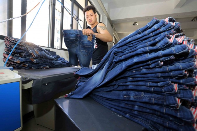 Foto tirada em maio de 2015 mostra trabalhador chinês fazendo calças jeans em uma fábrica de vestuário em Shishi, província de Fujian, no leste da China (STR/AFP/Getty Images)