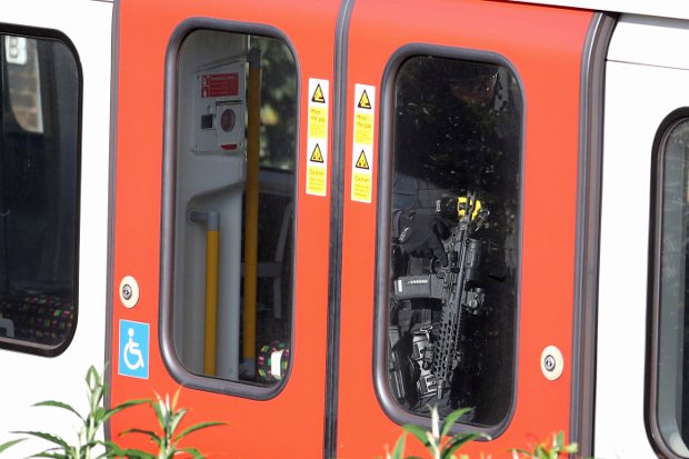 Policiais armados andando por um vagão de uma linha de metrô na estação Parsons Green, em Londres (Hannah McKay/Reuters)
