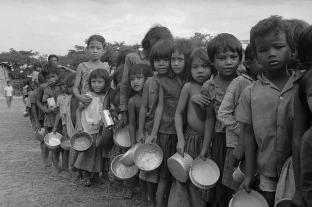 Crianças refugiadas cambojanas, que fugiram com suas famílias após as incursões do Khmer Vermelho, esperam por comida em um posto de auxílio fora de Phnom Penh em 1975 (Tea Kim Heang e Cara de Luna/AP Photo)