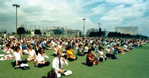 Praticantes do Falun Dafa na França realizando exercícios de meditação em grupo em 1999