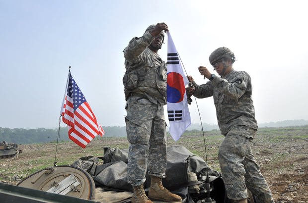 Soldados da 2ª Divisão de Infantaria dos EUA penduram uma bandeira sul-coreana no topo de seu tanque M1A2 durante um exercício conjunto na cidade fronteiriça de Yeoncheon, no nordeste de Seul, em 30 de maio de 2013 (Jung Yeon-je/AFP/Getty Images)