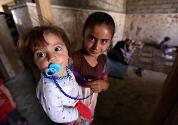 Crianças iraquianas Yazidi que fugiram da violência no norte da cidade iraquiana de Sinjar com sua família estão refugiadas em uma escola na cidade curda de Dohuk, na região autônoma do Curdistão, no Iraque, em 5 de agosto de 2014 (Safin Hamed/AFP/Getty Images)