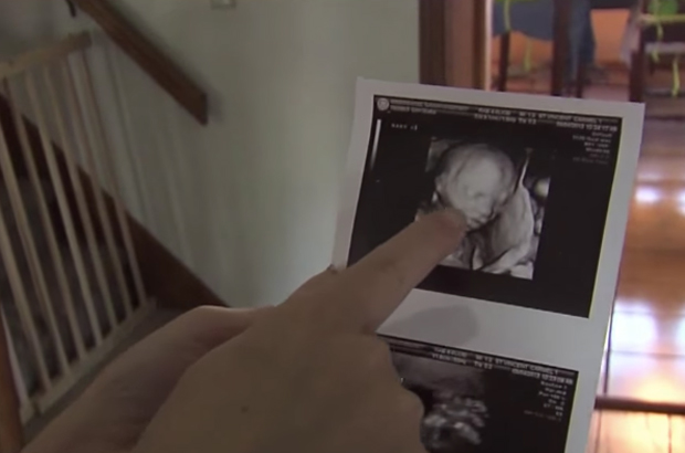 Sarah mostra uma imagem de sua ultrassonografia (RTV6 The Indy Channel/©YouTube)