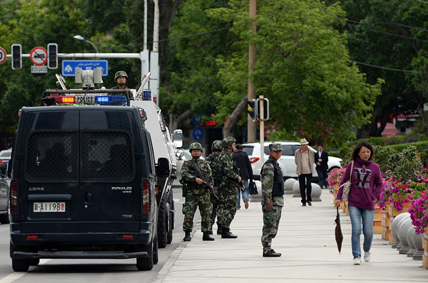 China, Xinjiang, uigur, extração forçada de órgãos, tráfico de órgãos - Policiais paramilitares chineses patrulham as ruas em Urumqi, Xinjiang, em 23 de maio de 2014 (Goh Chai Hin/AFP/Getty Images)