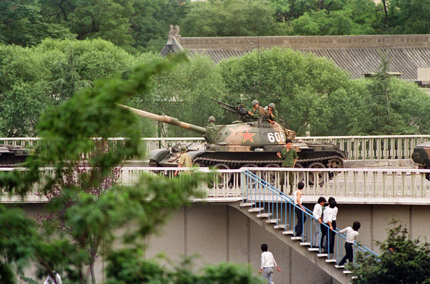 China, Partido Comunista Chinês, massacre da Praça da Paz Celestial - Espectadores chineses fogem quando um soldado os ameaça com uma arma no dia 5 de junho de 1989, quando tanques se posicionaram nas principais interseções de Pequim ao lado do complexo diplomático (Catherine Henriette/AFP/Getty Images)