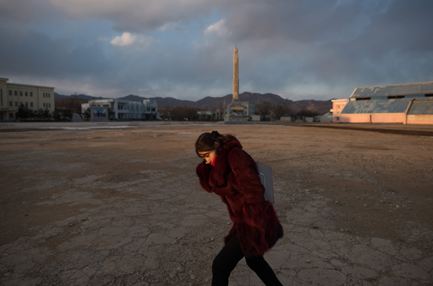 Coreia do Norte, Coreia do Sul, ideologia, socialismo, liberdade - Uma mulher se protege do frio num porto em Rason, no extremo nordeste da Coreia do Norte, na fronteira com a China e a Rússia, em 21 de novembro de 2017 (Ed Jones/AFP/Getty Images)