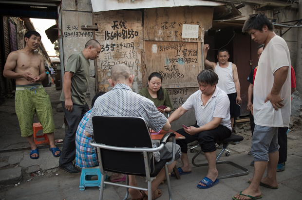 China, Partido Comunista Chinês, Xi Jinping, empresariado, pobreza - Chineses jogam carteado num bairro de imigrantes na periferia de Pequim em 20 de junho de 2017 (Nicolas Asfouri/AFP/Getty Images)