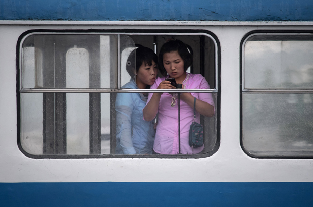 Coreia do Norte, Kim Jong-un, criminoso, sanções - Mulheres norte-coreanas olham um telefone celular num transporte público em Pyongyang em 6 de junho de 2017 (Ed Jones/AFP/Getty Images)