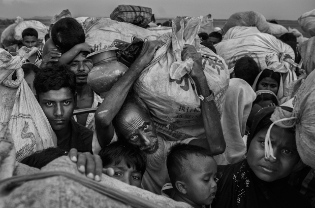 Myanmar, Birmânia, história, violência, rohingya, refugiados, muçulmanos - Refugiados muçulmanos rohingya esperam para prosseguirem para acampamentos depois de atravessarem a fronteira de Myanmar para Bangladesh numa passagem estreita de barro nas margens do Rio Naf, perto de Anjuman Para, em Cox's Bazar, Bangladesh, em 2 de novembro de 2017 (Kevin Frayer/Getty Images)