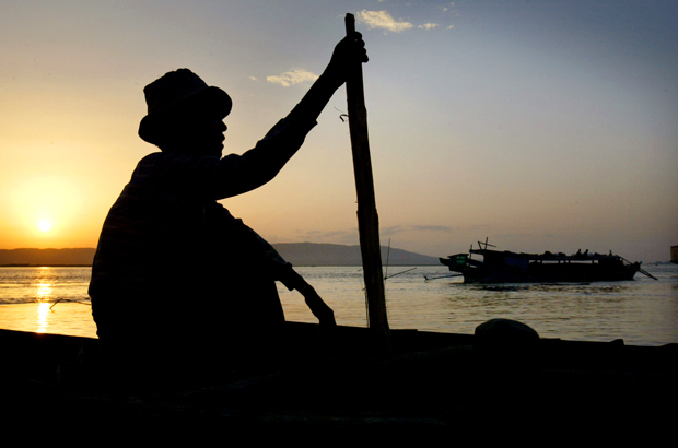 Myanmar, Birmânia, história, violência, rohingya, refugiados, muçulmanos - Um trabalhador navega seu barco no Rio Ayerarwady após um dia de trabalho num campo de exploração madeireira em Mandalay, Myanmar, em 15 de junho de 2003 (Paula Bronstein/Getty Images)
